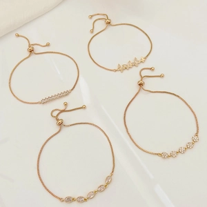 Detail of adjustable gold bracelets with butterfly and floral cubic zirconia charms