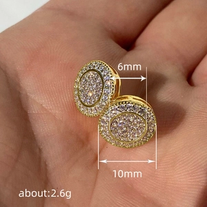 Classic 10mm golden round stud earrings with paved white cubic zirconia held in hand