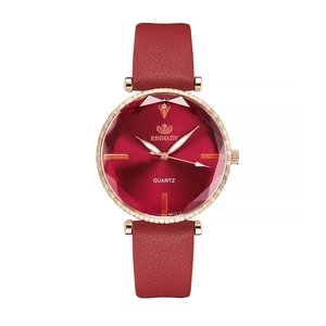 Detailed macro view of the faceted glass crystal on a red leather quartz watch
