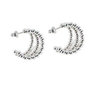 Detail view of silver C-shaped earrings with triple rows of metal beads and polished finish