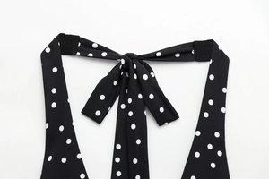Detail shot of black and white polka dot halter neck tie on a women's summer top