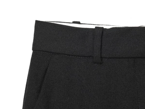 Detail of waist belt loops and side pocket stitching on black tailored trousers