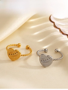 Detail of gold and silver heart rings with sandblasted texture and twisted rope band