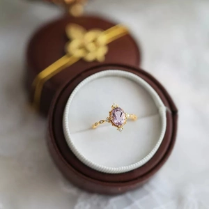 Macro shot of oval faux amethyst ring with diamonds in a vintage jewelry box