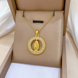 Macro detail of gold medallion necklace featuring Virgin Mary relief and crystal halo