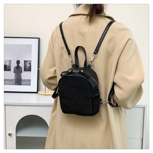 Close-up of black mini backpack with rhinestone studs and silver metal zipper detail