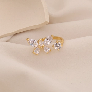 Verstellbarer 18K Gold Schmetterlingsring mit Zirkonia auf Seidenhintergrund