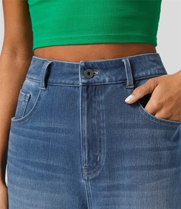Dettaglio jeans a vita alta con cuciture, passanti per cintura e bottone metallico