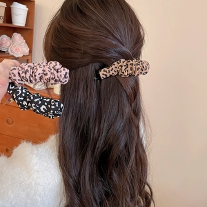 Detail of leopard print fabric hair scrunchies in pink, brown and black colors