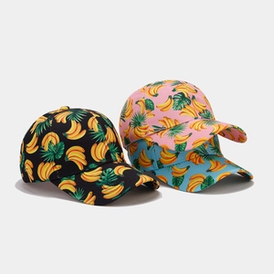 Detailed close-up of tropical banana pattern baseball caps in black, pink, and blue colors
