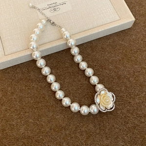 Elegant multi-layer pearl necklace featuring a diamond-set camellia flower pendant