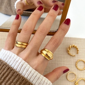 Detail eines Goldring-Sets mit poliertem breitem Band und gedrehtem Seiltextur-Design