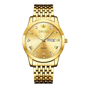 Detail of gold quartz watch face with luminous hands and day-date display window