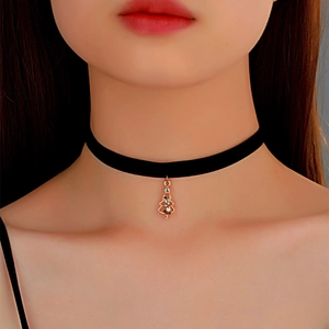 Close-up of velvet choker with a gold Christmas tree pendant and colorful rhinestones
