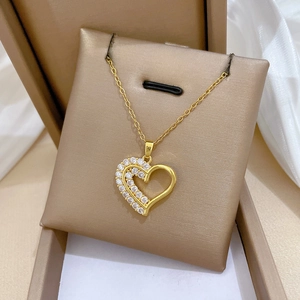 Gros plan d'un collier double rang avec cœur doré et cristaux sur tissu en soie