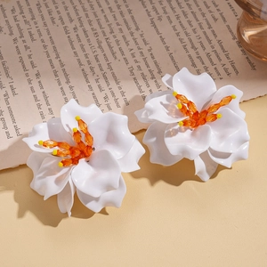 Chic acrylic white 3D flower earrings with orange beaded center on vintage paper