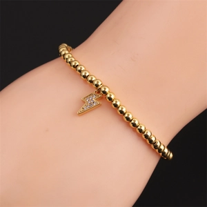 Bracelet élégant à perles dorées avec un pendentif éclair étincelant serti de zircons