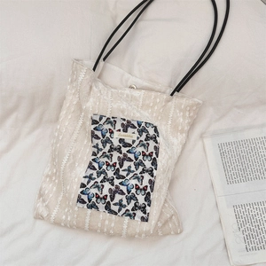 Détail du sac cabas en toile avec rayures en dentelle, motif papillon et étiquette Soraika