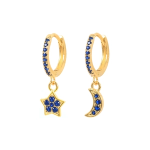 Macro detail of asymmetric gold star and moon hoop earrings with deep blue pavé stones