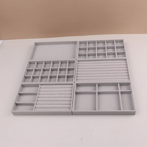 Macro detail of various grey velvet jewelry tray inserts with multiple compartments