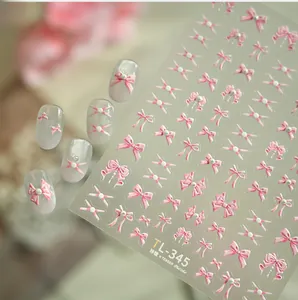 Detail view of 3D pink bow nail stickers and pearl accents on elegant manicure tips