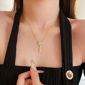 Nahaufnahme der vergoldeten Schlüsselkette mit rosa Herzzirkon am Modelhals