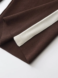 Close-up of dark brown knit fabric with vertical white stripes and refined texture