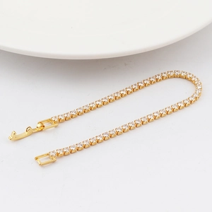 Close-up of a gold tennis bracelet with zircon stones and a secure folding clasp
