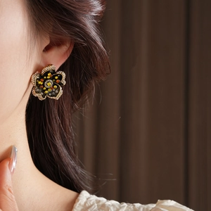 Close-up of vintage flower earrings with multicolored rhinestones and gold trim