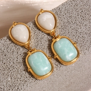 Macro shot of 18K gold plated titanium steel earrings with amazonite stones on stone base