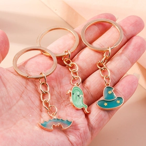 Detail of Halloween charms featuring a bat, ghost, and wizard hat with gold plating