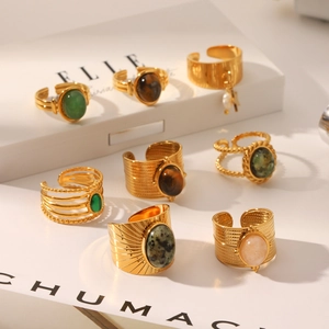 Detailed macro shot of vintage gold stainless steel rings with colorful gemstones on a book