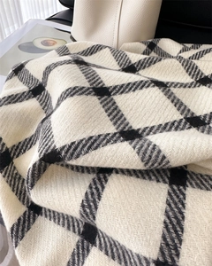 Close-up of black and white plaid scarf fabric texture with soft cashmere-like feel