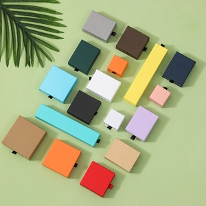 Premium matte drawer jewelry boxes in various colors and sizes on green background
