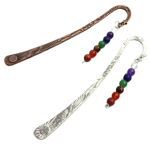 Bronze and silver feather bookmarks with seven chakra natural stone beads on white background