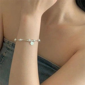Close-up of minimalist 925 silver beaded bracelet with a smooth round pendant on wrist