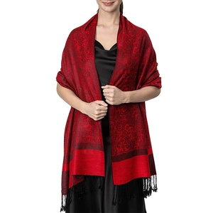 Detail of red and black paisley shawl with fringe on a model in studio lighting