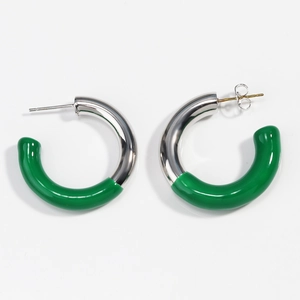 Vue détaillée de boucles d'oreilles argentées en C avec résine verte sur fond blanc