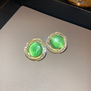 Vista macro di orecchini vintage dorati con pietra occhio di gatto verde e strass
