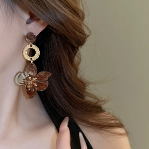 Close-up of vintage resin flower drop earrings with amber tones and gold metal rings