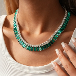 Primo piano di una collana di lusso con smeraldi verdi rettangolari e diamanti bianchi