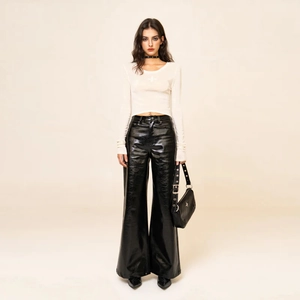 Set donna con crop top bianco a maniche lunghe e pantaloni disco neri lucidi a gamba larga
