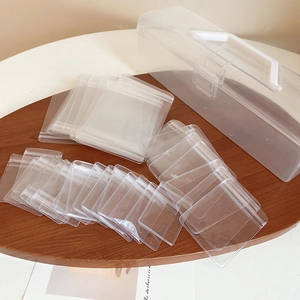 Close-up of portable transparent jewelry organizer with individual zip bags on wood tray