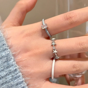 Close-up of three layered rings featuring blue enamel, silver stars, and white details
