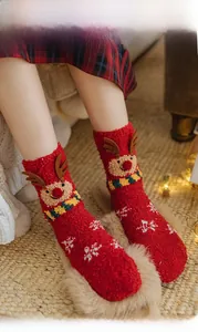 Detail of red Christmas coral fleece socks with 3D reindeer design and snowflake patterns