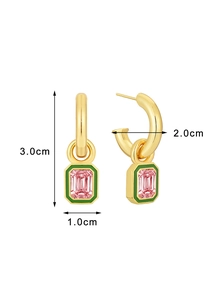 Dettaglio di orecchini geometrici dorati con smalto verde e pietra di zircone rosa