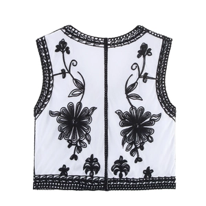 Detail view of ethnic white vest with black floral embroidery and crochet edge