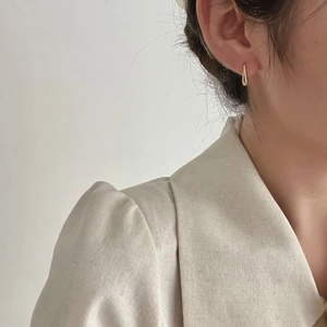 Close-up of minimalist golden teardrop earrings on model for an elegant look
