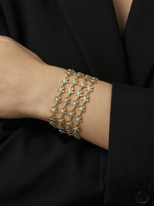 Detailed shot of 18k gold plated multi-layer bracelet with blue enamel flower charms