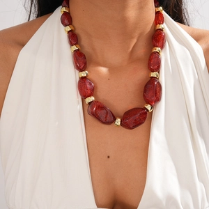 Detail shot of vintage acrylic chunky necklace with red glitter beads and gold accents